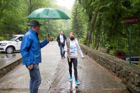 Prihod olimpijske bakle k Županovi jami v dežju. Foto Marjan Trobec